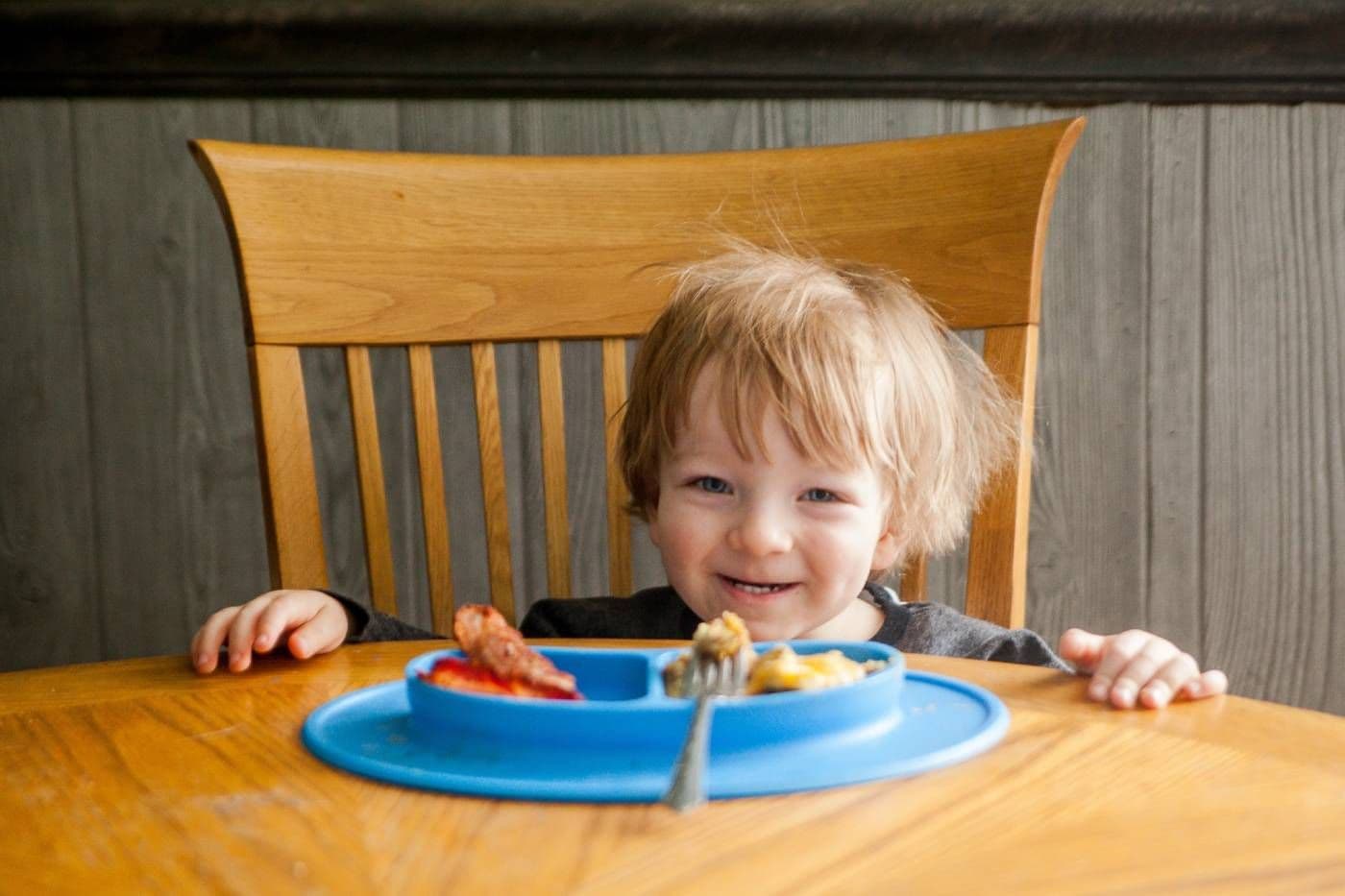 Toddler sits at the table to eat