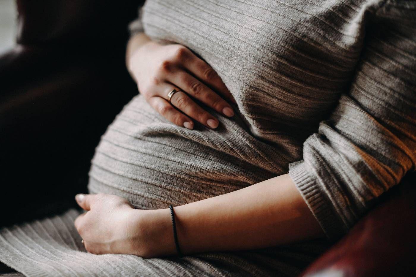 An expectant mother cradles her belly