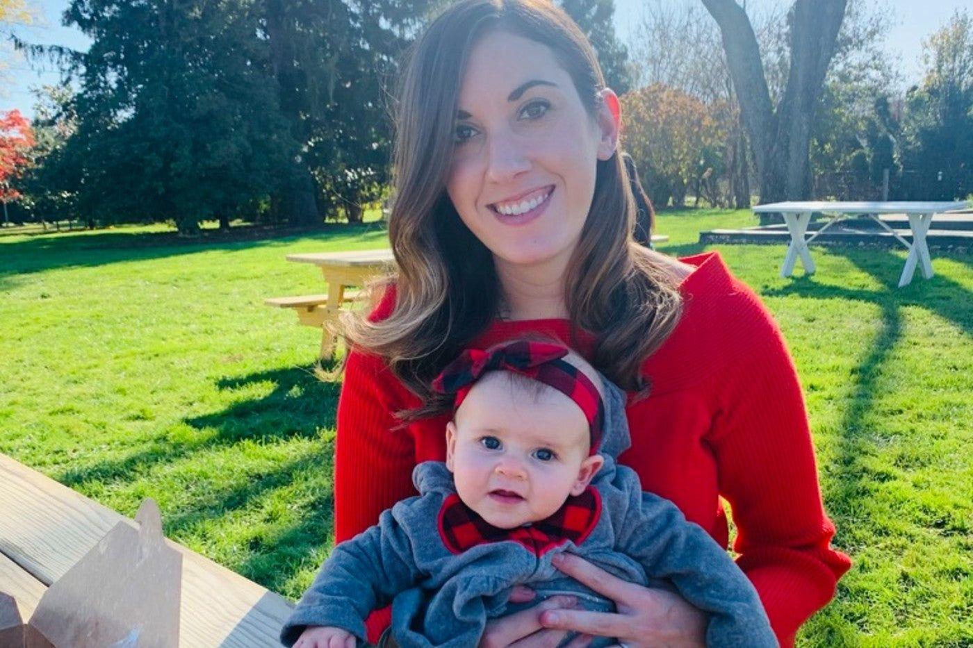 Mum holding baby girl at a park.
