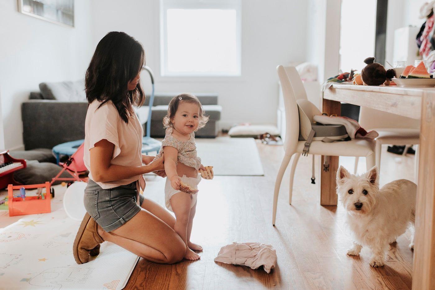 A mum dresses her toddler daughter