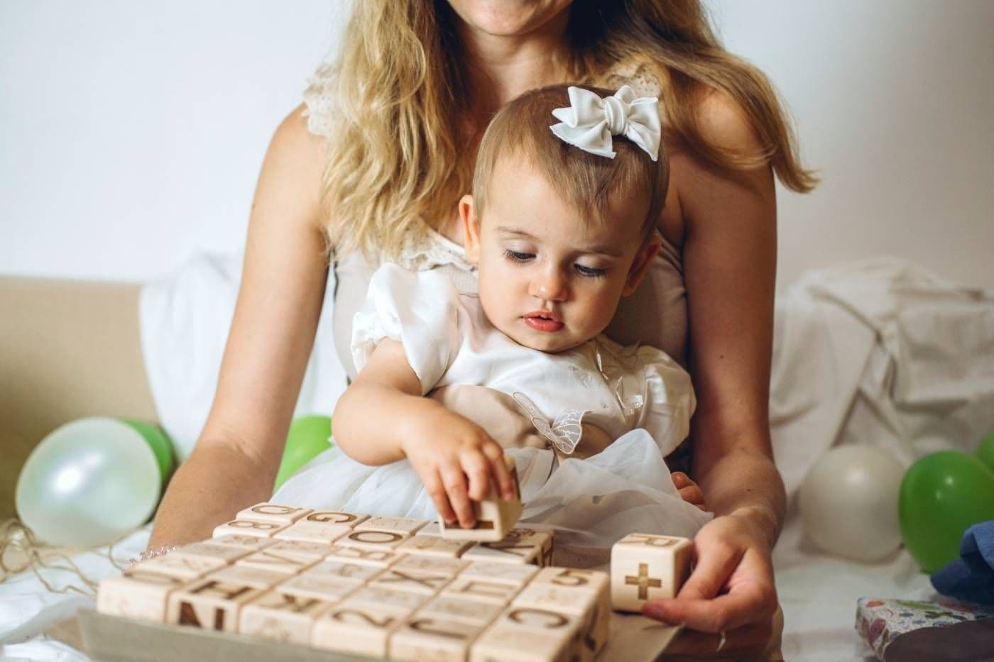 A toddler girl plays with wooden blocks