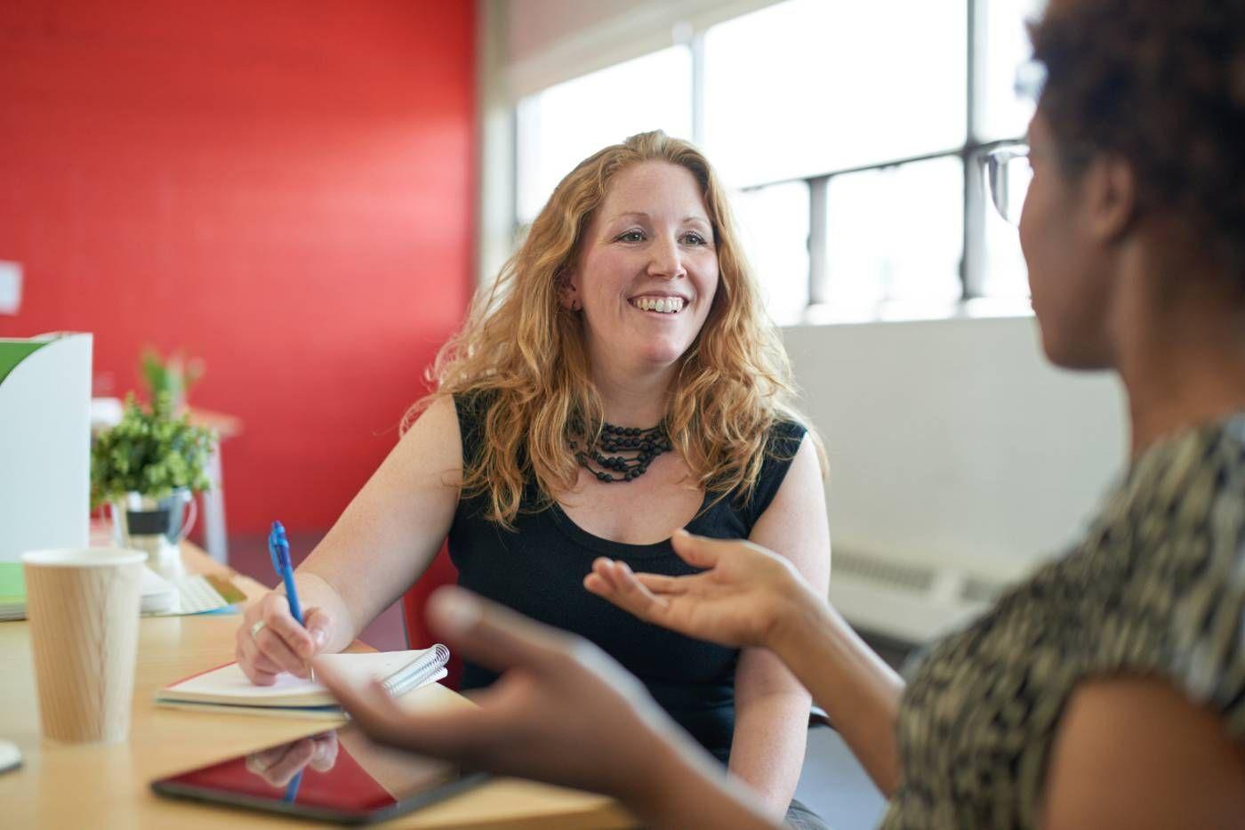 New mom chatting with coworker after returning from parental leave