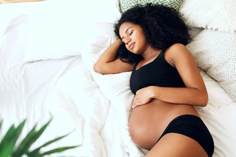 Pregnant woman sleeping with hand on belly