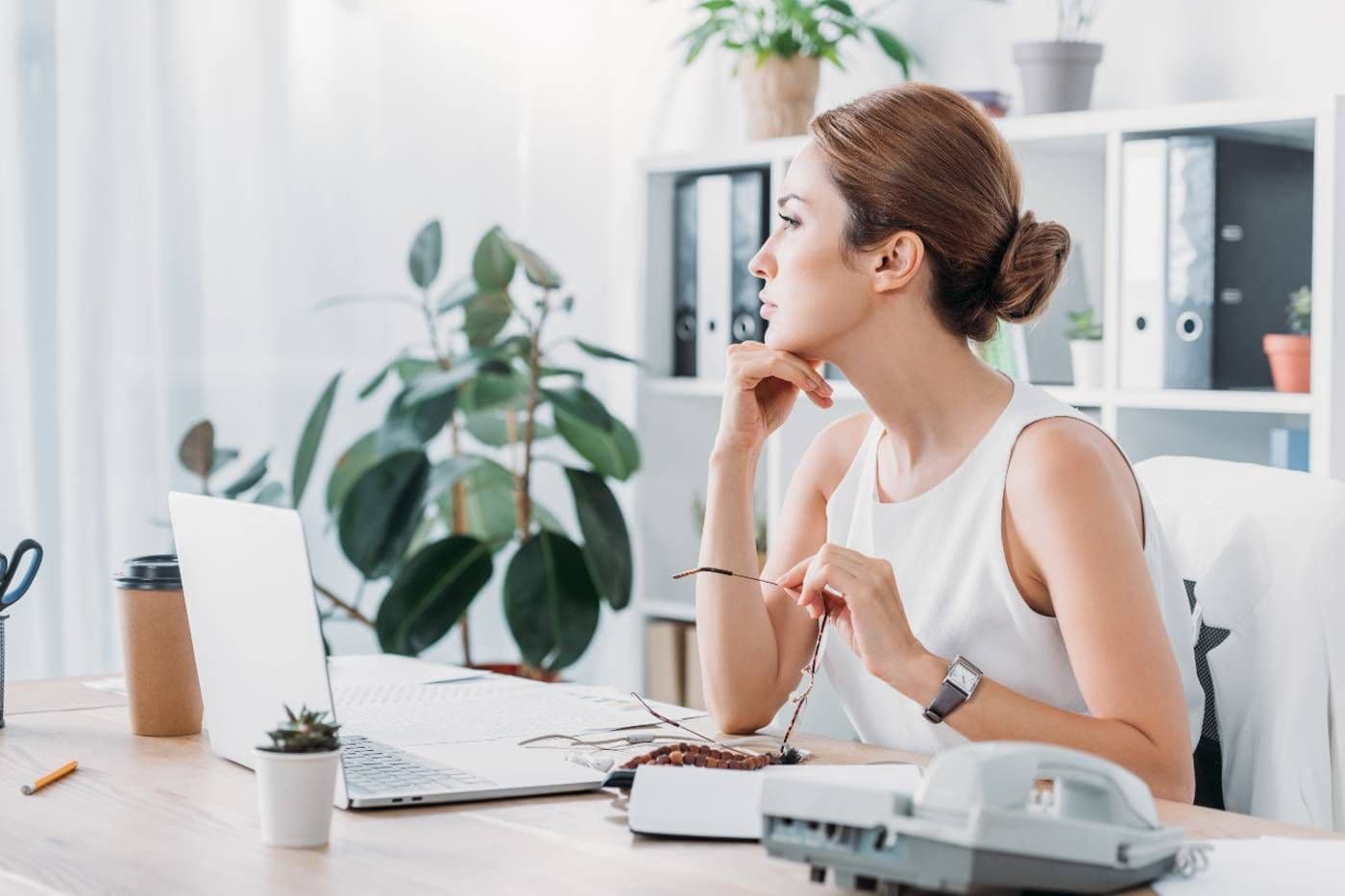 A mum contemplates when to tell her boss she's pregnant at her desk