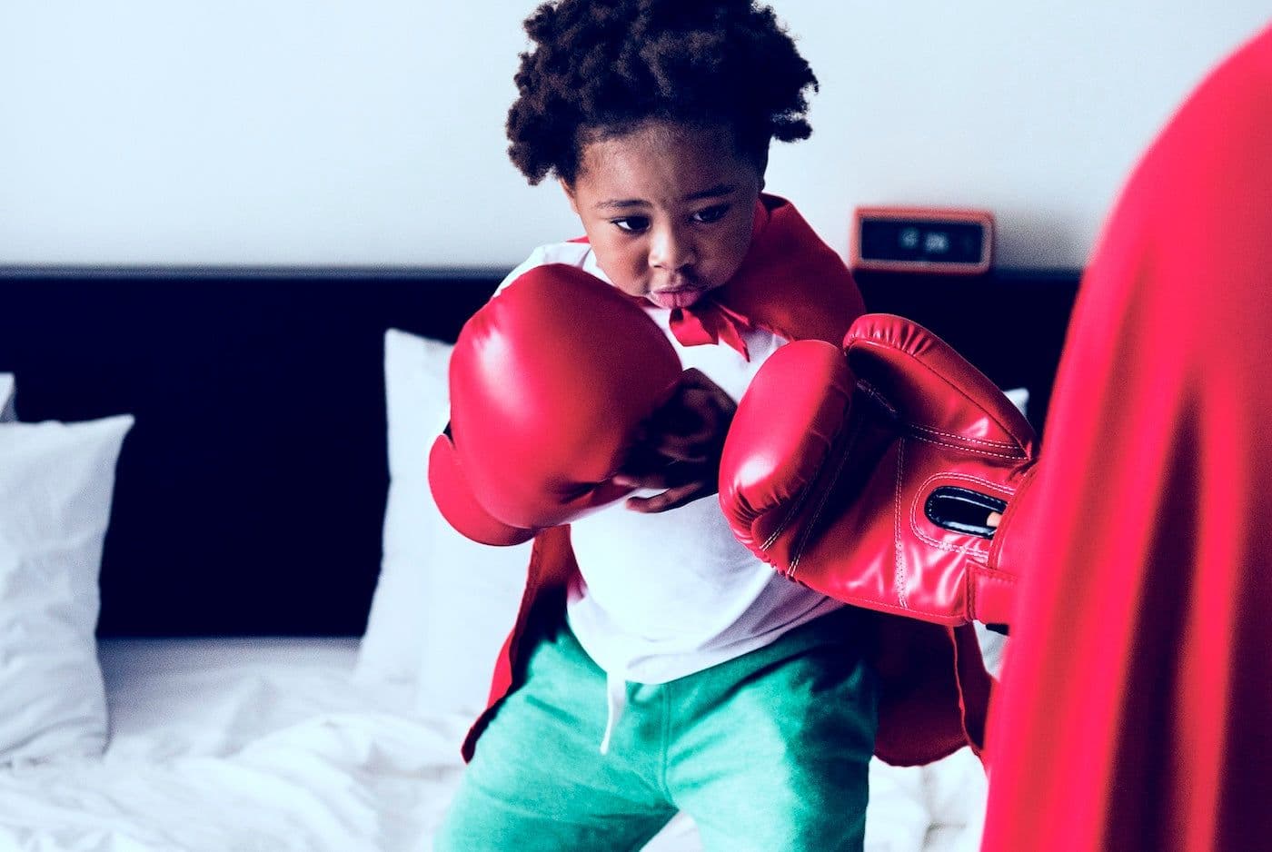 Toddler boy dressed in boxing gloves