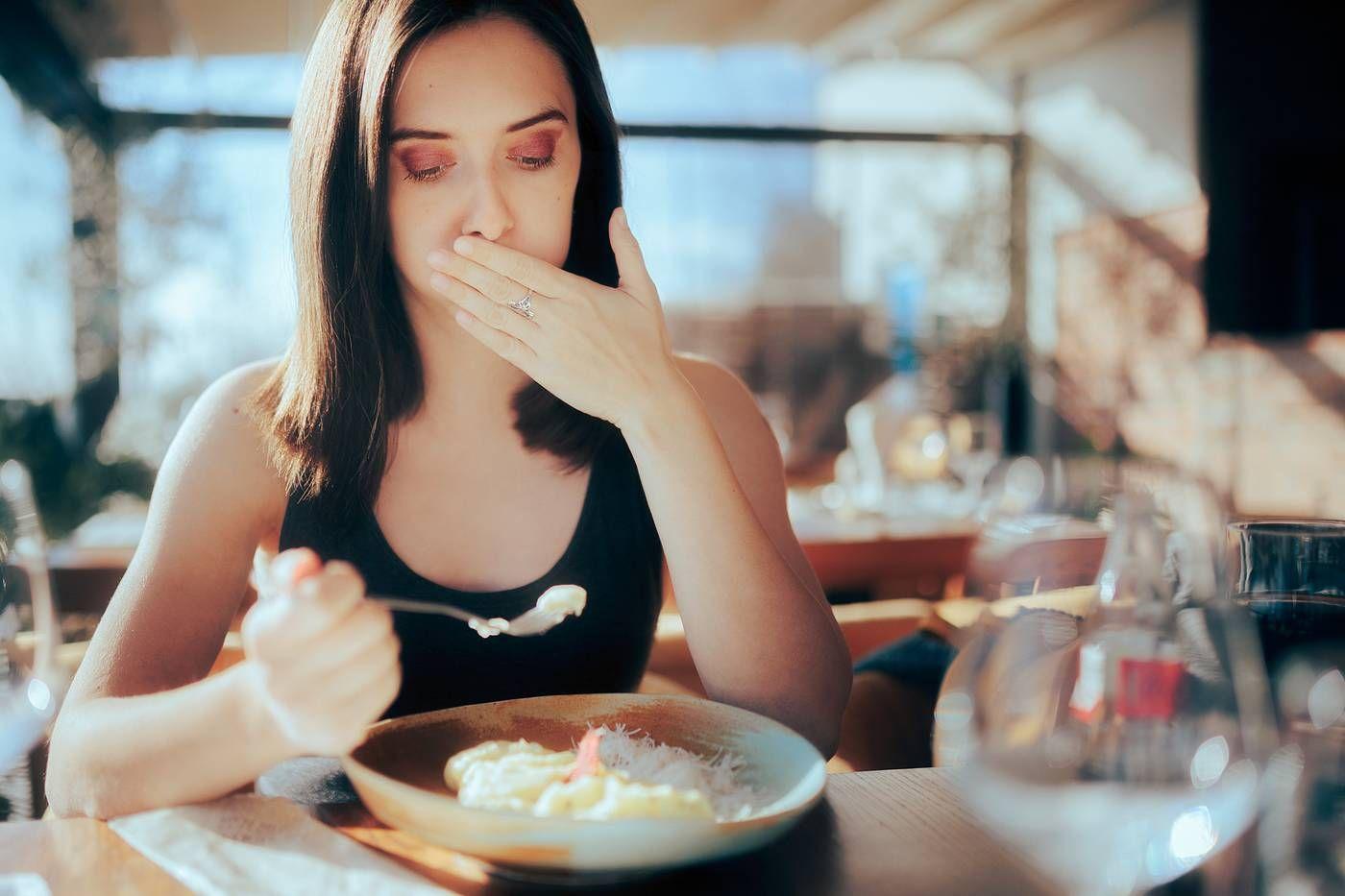 A woman is nauseated by her meal