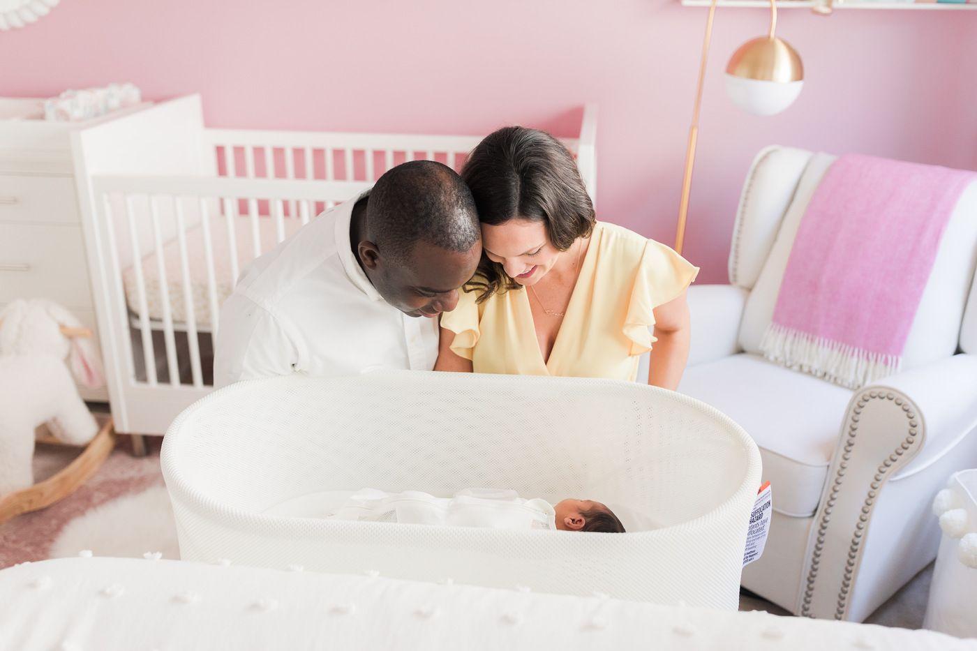 A couple looks at their baby in SNOO Smart Sleeper