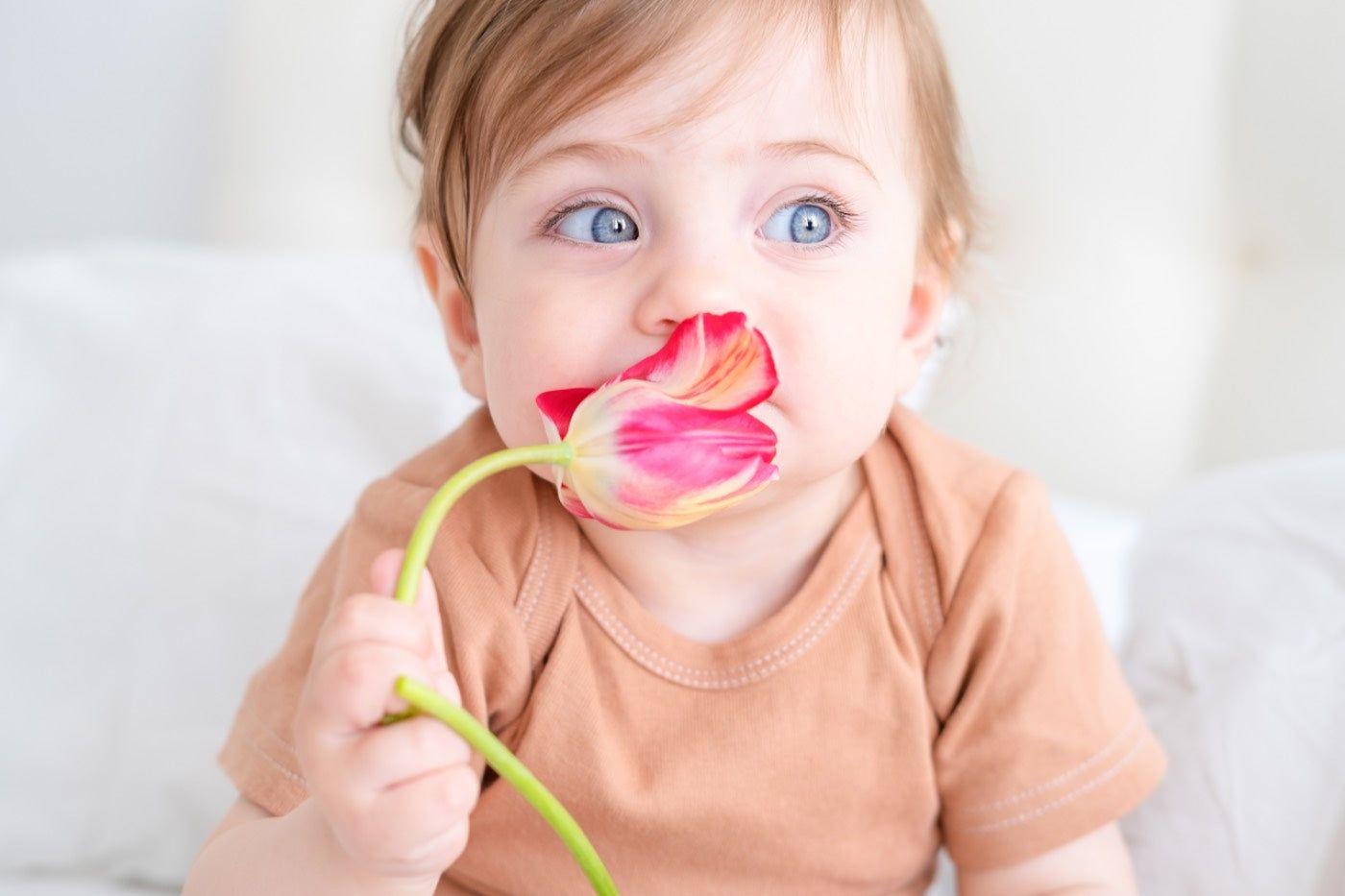 flower and botanical baby names: baby holding a flower
